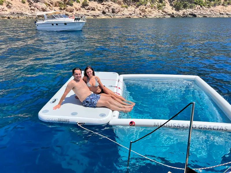 Couple relaxing with anti-jellyfish pool set in Menorca