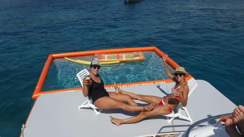 Two women relaxing on inflatable platform with jellyfish pool in Mallorca
